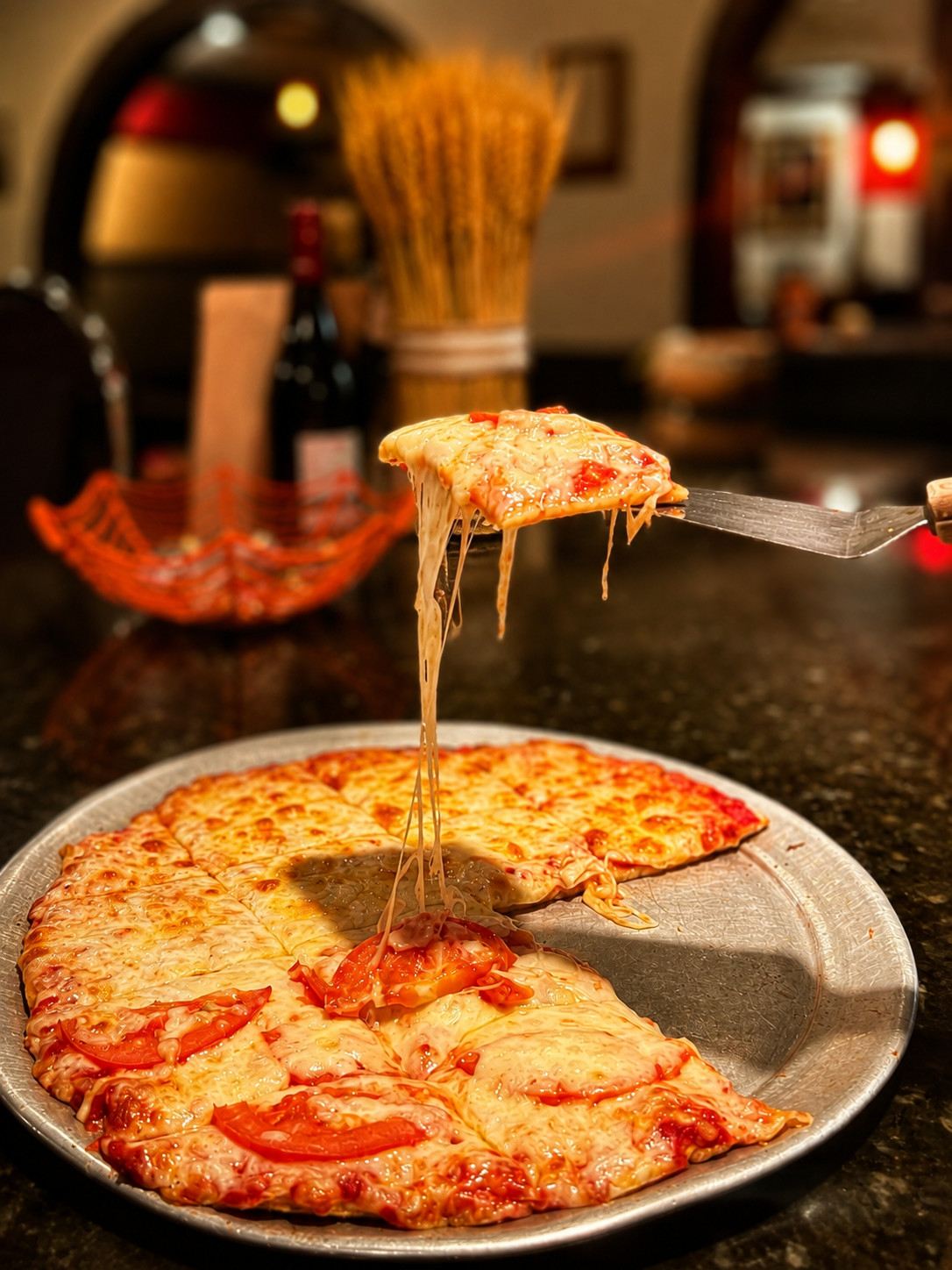 Guido’s thin crust pizza with a lifted slice and melted cheese